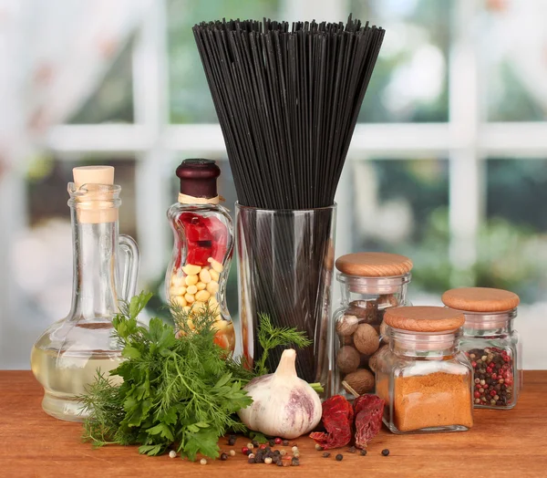 Pasta de espaguetis, verduras y especias en la mesa de madera sobre fondo brillante — Foto de Stock