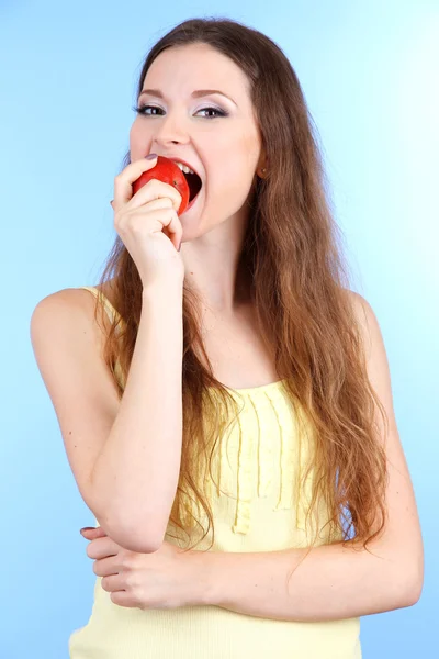 Beautiful woman with apple on blue background — Stock Photo, Image