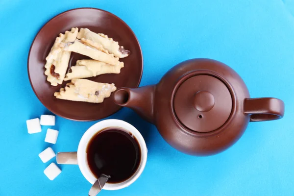 Draufsicht auf Tasse Tee und Teekanne auf blauen Tischdecken — Stockfoto