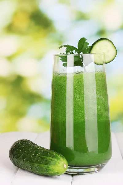 Vaso de jugo de pepino sobre mesa de madera, sobre fondo verde — Foto de Stock