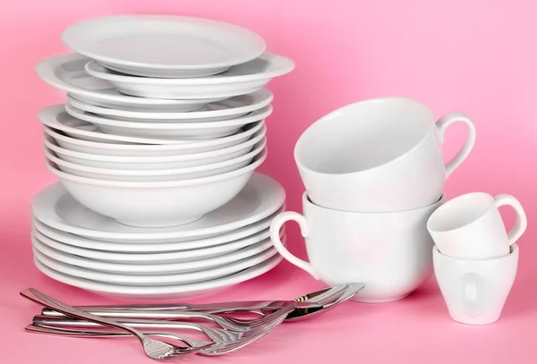 Clean white dishes on pink background — Stock Photo, Image