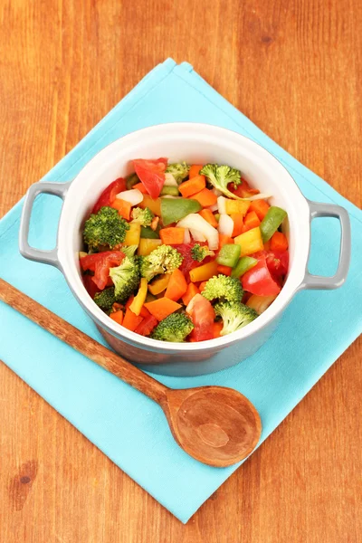 Ragoût de légumes en pot gris sur serviette de couleur sur fond en bois — Photo