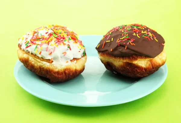 Donuts saborosos na placa de cor no fundo de cor — Fotografia de Stock