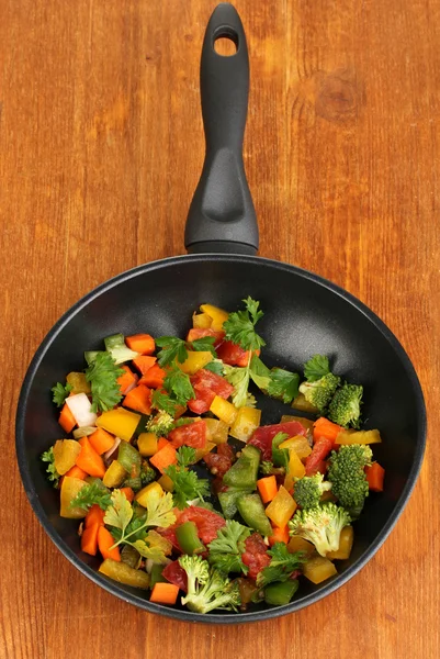 Légumes frais tranchés dans une casserole sur une table en bois — Photo