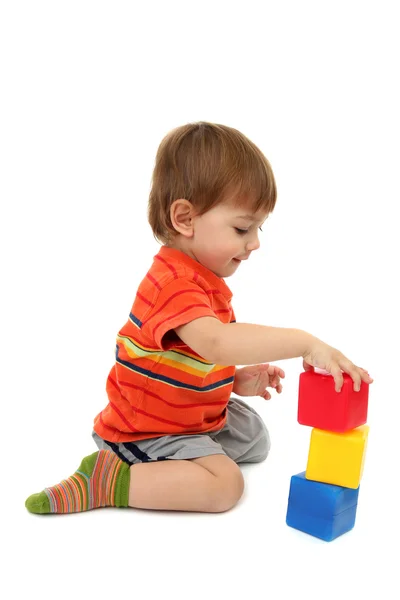 Schattige kleine jongen met speelgoed Kleurkubussen, geïsoleerd op wit — Stockfoto