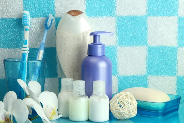 Accesorios de baño en el estante en el baño sobre fondo de pared de azulejo azul — Foto de Stock