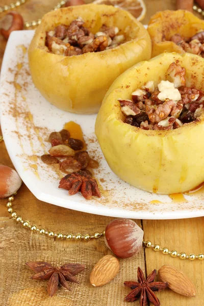 Baked apples on plate on wooden table — Stock Photo, Image