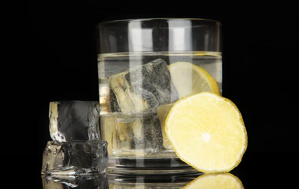 Cubos de hielo en vidrio con limón aislado en negro —  Fotos de Stock