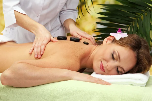 Retrato de mujer hermosa con piedras de spa tomando masaje en la cabeza —  Fotos de Stock