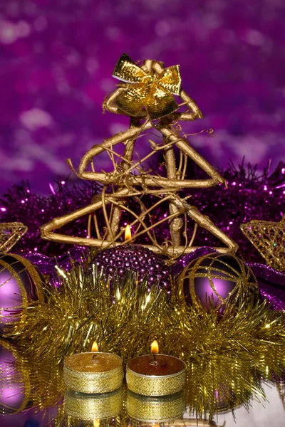 Composição de Natal com velas e decorações em roxo e ouro cores sobre fundo brilhante — Fotografia de Stock