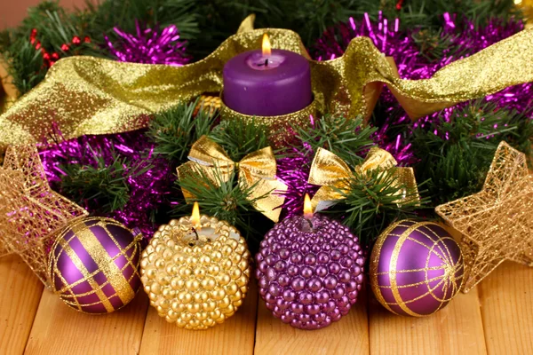 Mumlar ve ahşap zemin üzerinde mor ve altın renkli süslemeleri Noel kompozisyonu — Stok fotoğraf