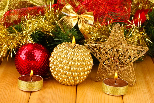 Χριστούγεννα σύνθεσης με κεριά και διακοσμήσεις σε κόκκινα και χρυσά χρώματα σε ξύλινα φόντο — Φωτογραφία Αρχείου