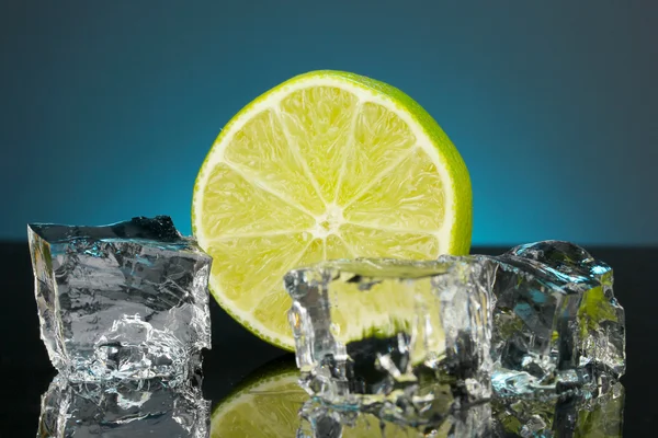 Ice cubes with lime on darck blue background — Stock Photo, Image