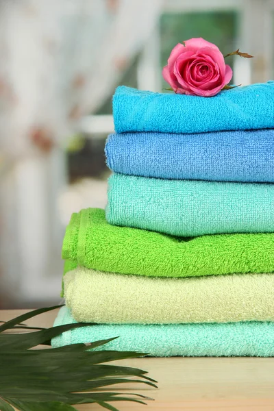 Stapel von Handtüchern mit duftender Blume auf Fensterhintergrund — Stockfoto