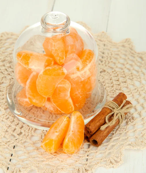 Tangerine on saucer under glass cover on light background — Stock Photo, Image