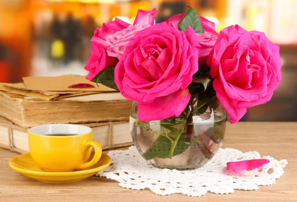 Hermosas rosas rosadas en jarrón sobre mesa de madera sobre fondo de habitación —  Fotos de Stock