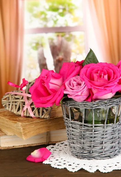 Belas rosas cor-de-rosa em vaso na mesa de madeira no fundo da janela — Fotografia de Stock