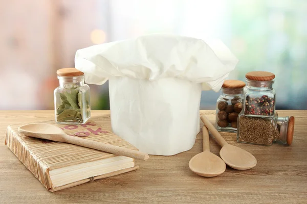 Chef's hat with spoons on table in kitchen — Stock Photo, Image