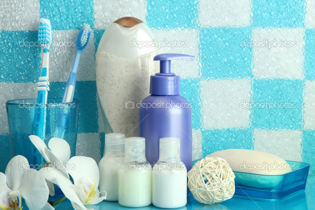 Bath accessories on shelf in bathroom on blue tile wall background
