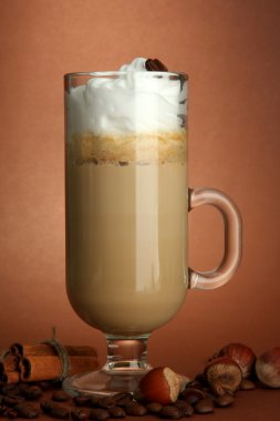 hoş kokulu kahve latte ile baharat, kahverengi zemin üzerine cam fincan