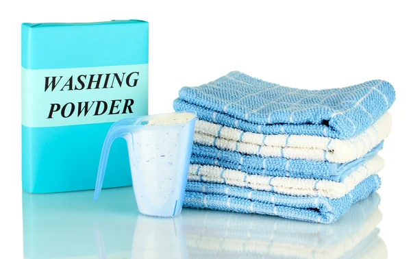 Box of washing powder with blue measuring cup and towels, isolated on white — Stock Photo, Image