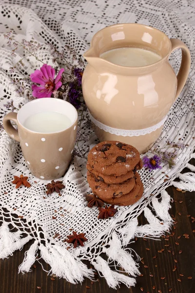 Jarra y taza de leche con galletas en la mesa de madera de cerca —  Fotos de Stock