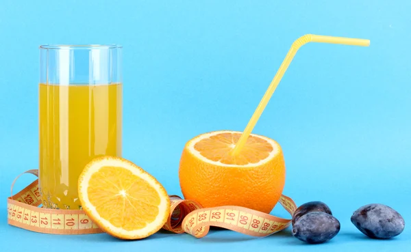 Ripe oranges and juice as symbol of diet on blue background — Stock Photo, Image