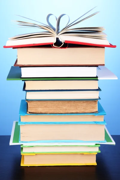 Stack of interesting books and magazines on wooden table on blue background — Zdjęcie stockowe