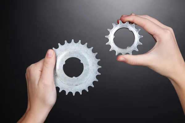 Man holding a pair of old metallic cogwheels in his hands — Stock Photo, Image