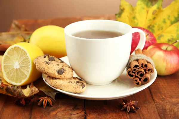 Tasse de thé chaud et feuilles d'automne, sur fond brun — Photo