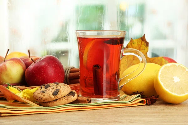 Tazza di tè caldo e foglie autunnali, sul tavolo di legno — Foto Stock