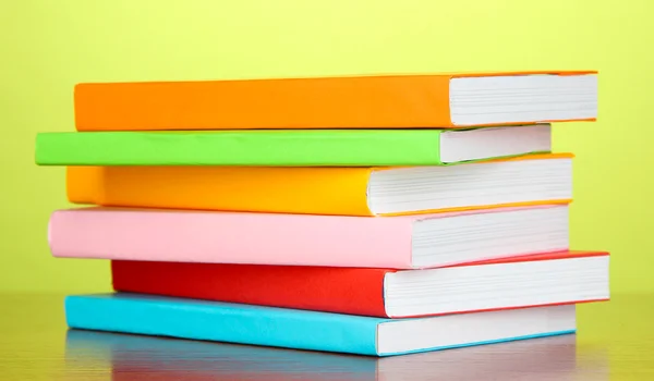 Stack of multicolor books on green background — Stock Photo, Image