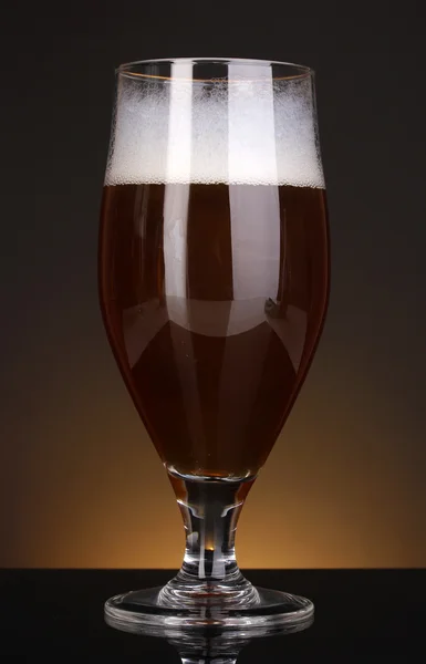 Glass of beer on brown background — Stock Photo, Image