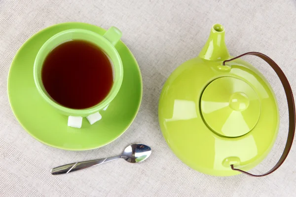 Vista superior de la taza de té y tetera en manteles — Foto de Stock