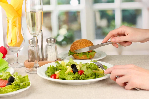 Kvindelig hånd med middag på lys baggrund - Stock-foto