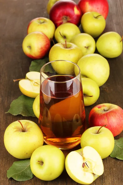 Användbara äppeljuice med äpplen runt på träbord — Stockfoto