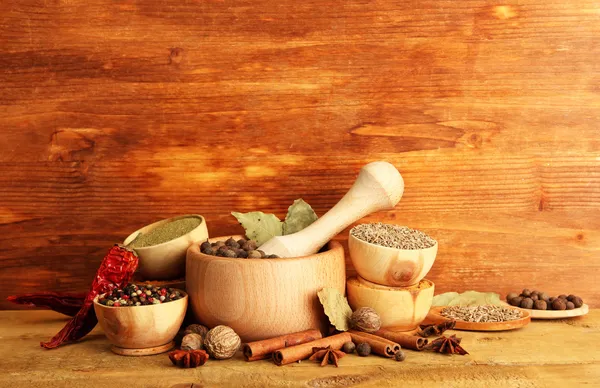 Malty, misky a lžičky s kořením, na dřevěné pozadí — Stock fotografie