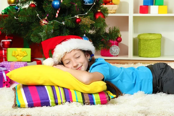 Little girl sleeping near christmas tree — Stock Photo, Image
