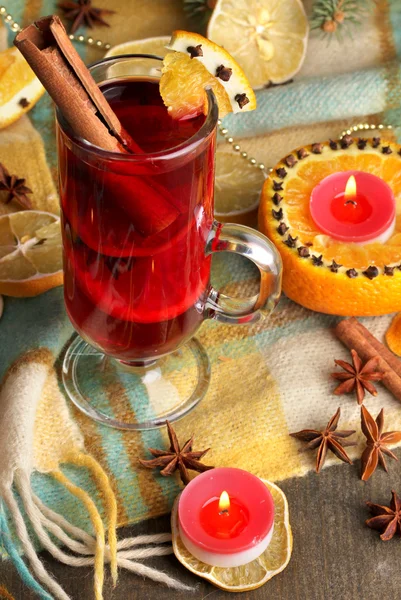 Geurige glühwein in glas met specerijen en sinaasappelen rond op houten tafel — Stockfoto