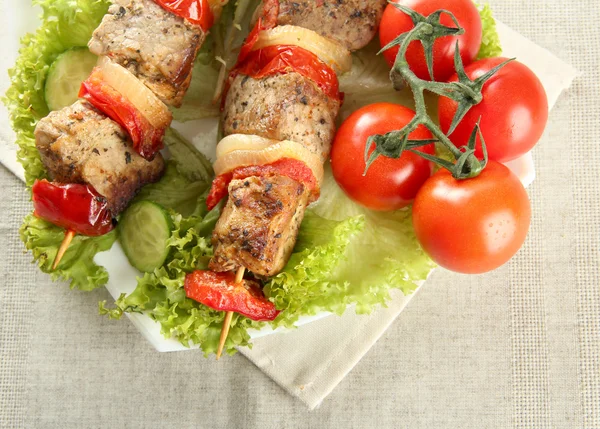 Смачне смажене м'ясо та овочі на шампурі на тарілці, на столі — стокове фото