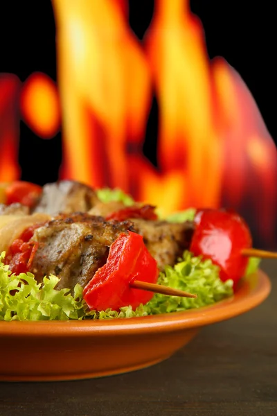 Sabrosa carne a la parrilla y verduras en el plato, sobre fondo de fuego — Foto de Stock