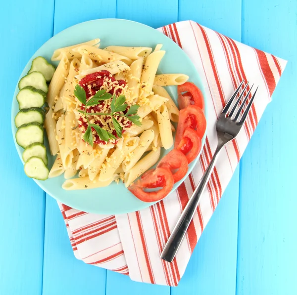 Plato de pasta Rigatoni con salsa de tomate sobre mesa de madera azul —  Fotos de Stock
