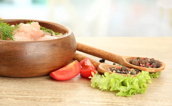 Raw chicken meat in bowl, on wooden table — Stock Photo, Image
