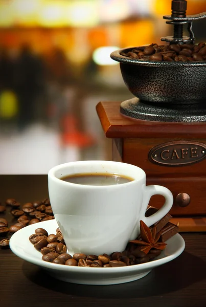 Cup of coffee, grinder and coffee beans in cafe — Stock Photo, Image