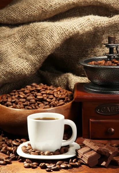 Coffee grinder and cup of coffee on burlap background — Stock Photo, Image