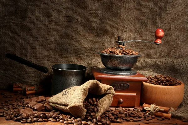 Coffee grinder, turk and cup of coffee on burlap background — Stock Photo, Image