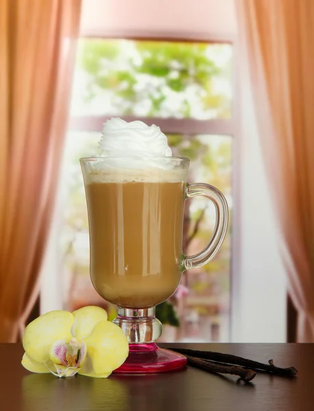 Μυρωδάτο καφέ latte στο γυαλί Κύπελλο με το λοβό βανίλιας, στο τραπέζι στο café — Φωτογραφία Αρχείου