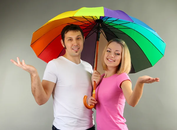 Casal amoroso com guarda-chuva no fundo cinza — Fotografia de Stock