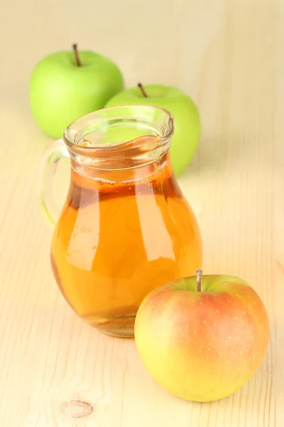 Full jug of apple juice and apple on wooden background — Stock Photo, Image