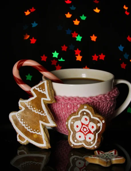 Cup of coffee with holiday candy on Christmas lights background — Stock Photo, Image